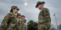 Drill Sergeant standing outside with recruits. 