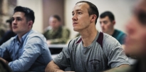 Soldiers and civilians in a classroom. 